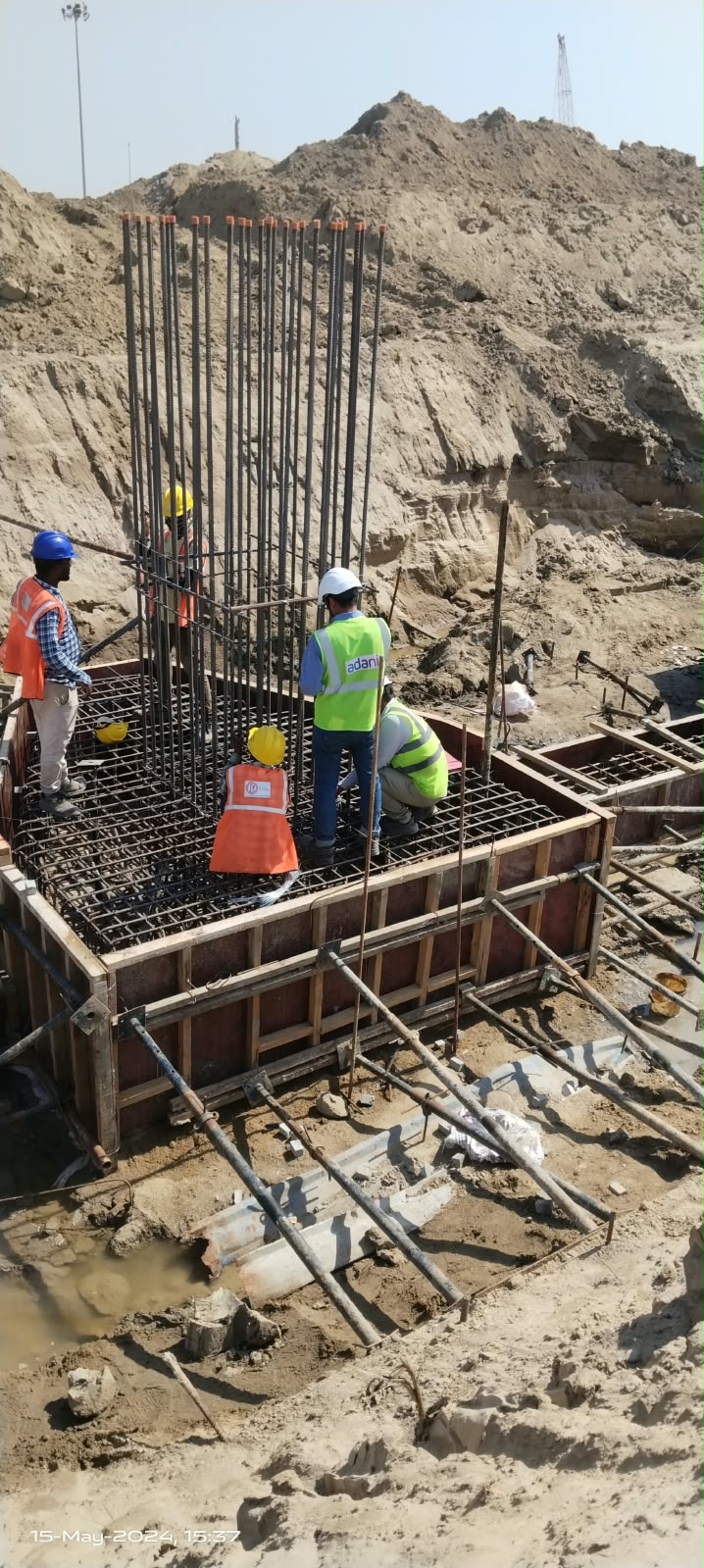 Workers assembling a reinforcement cage on a pile cap